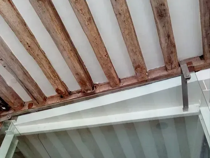 Faux plafond à côté d'un plafond avec des poutres apparentes