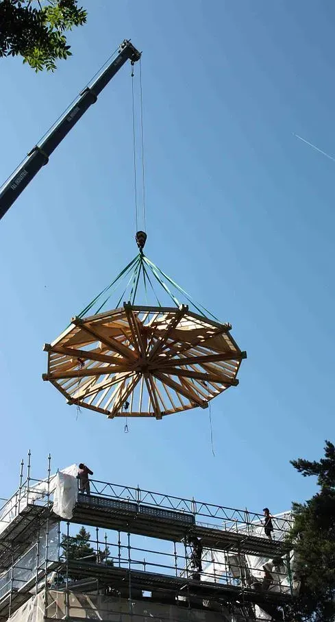 Pose d'une charpente circulaire à l'aide d'une grue