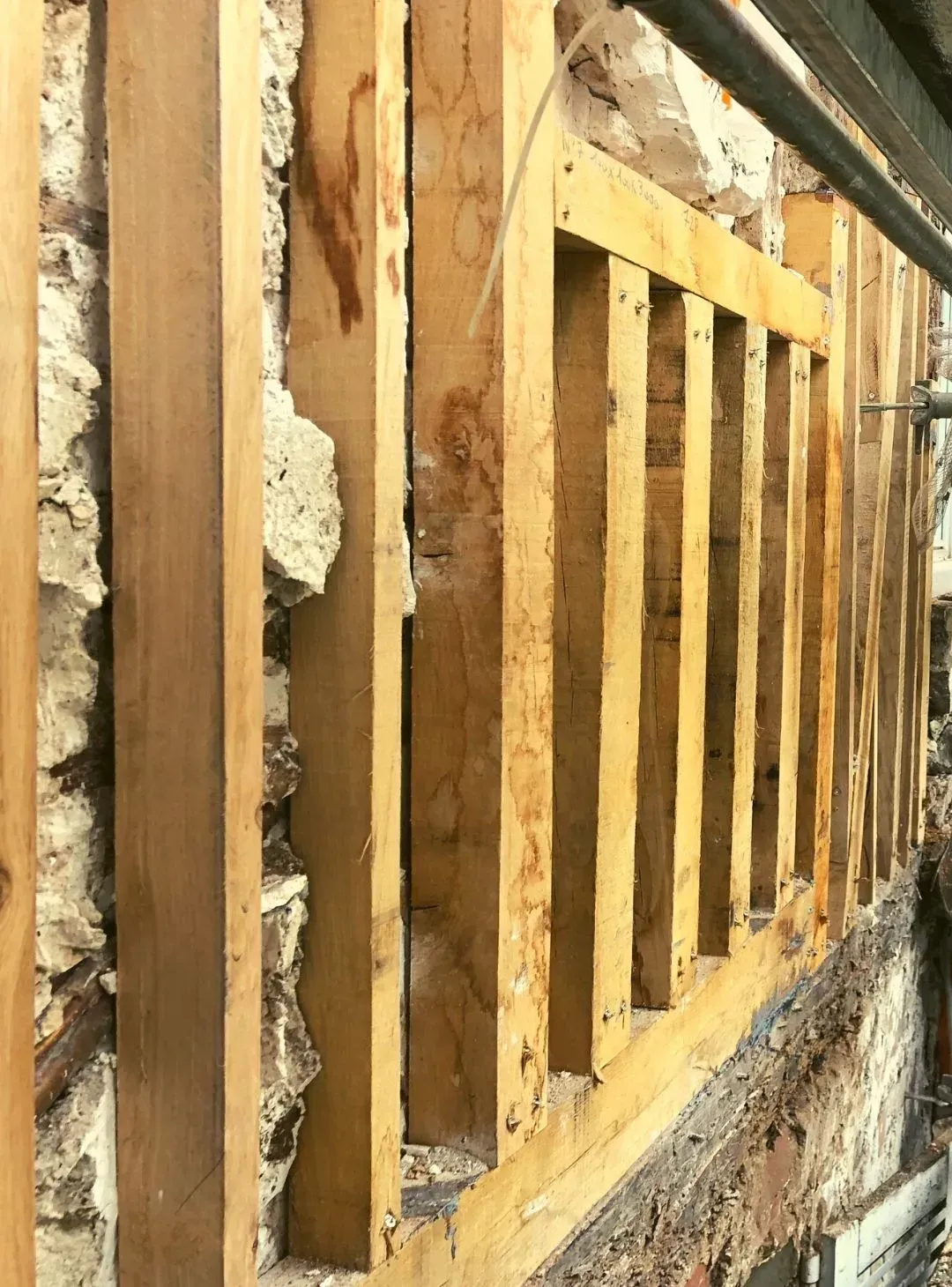 Pan de bois le long d'un mur en pierre