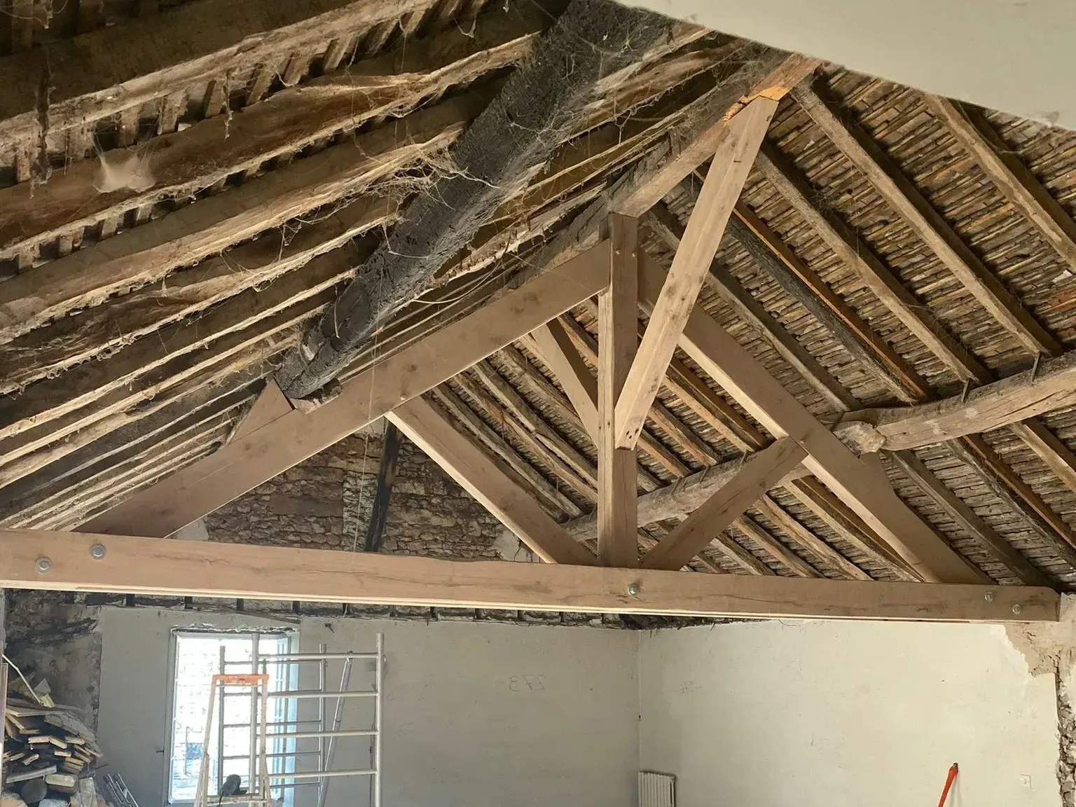 Charpente à fermettes rénovée d'une maison en pierre