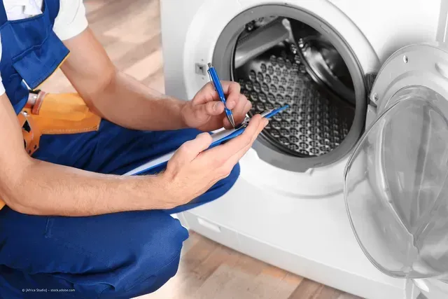 Techniker überprüft Waschmaschine