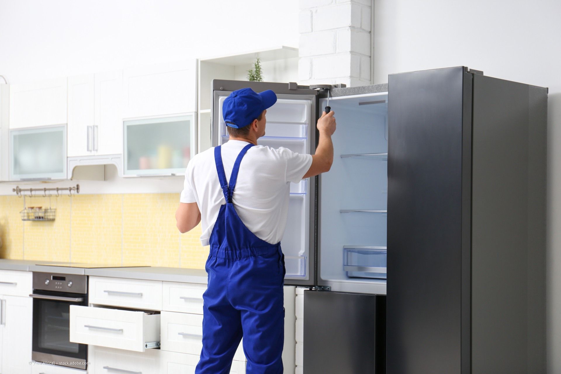 Techniker baut Kühlschrank ein