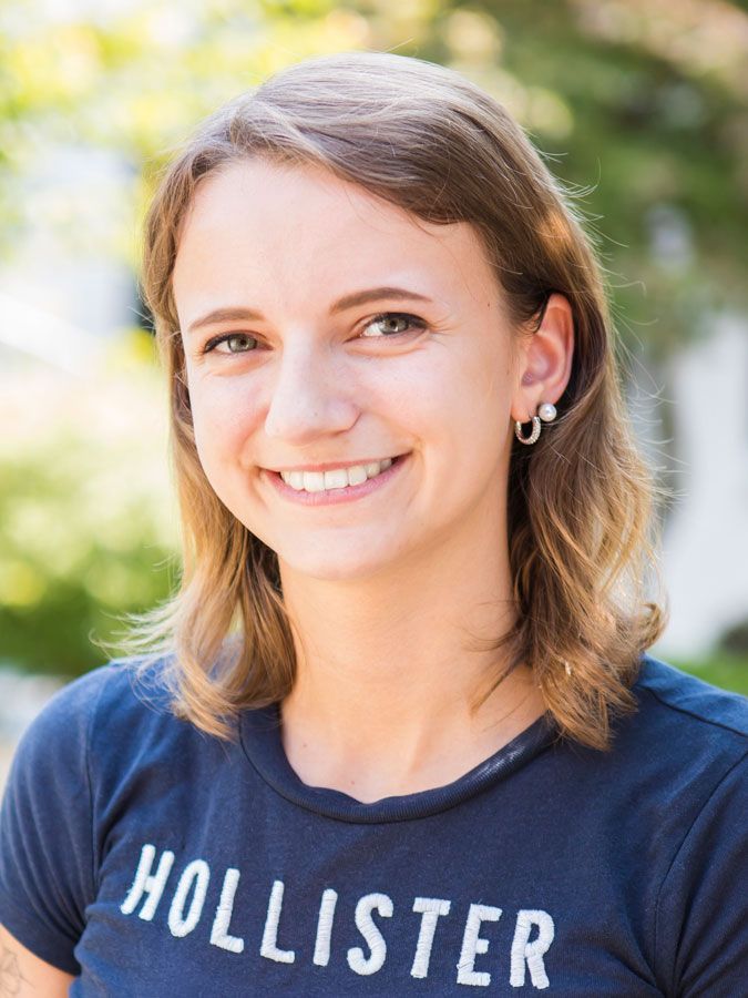 Eine Frau in einem blauen Hollister-Shirt lächelt in die Kamera.