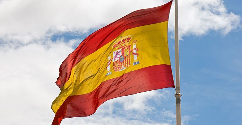 Una bandera española ondea en el viento contra un cielo azul