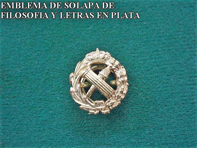 Emblema de solapa de filosofía y letras en plata is displayed on a green cloth