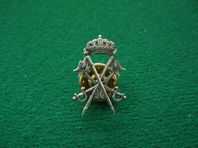 Un alfiler con una corona y espadas cruzadas.