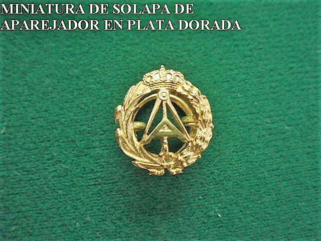 Una insignia dorada con la palabra miniatura.