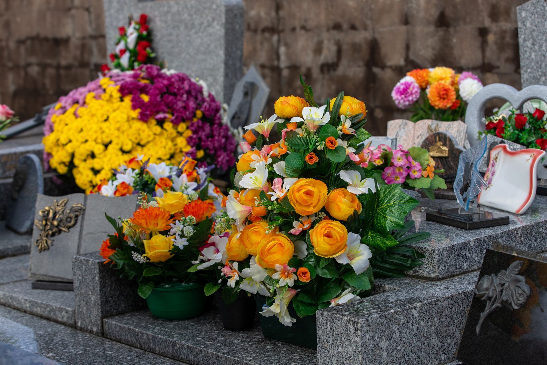 Des fleurs et des plaques posées sur une tombe.