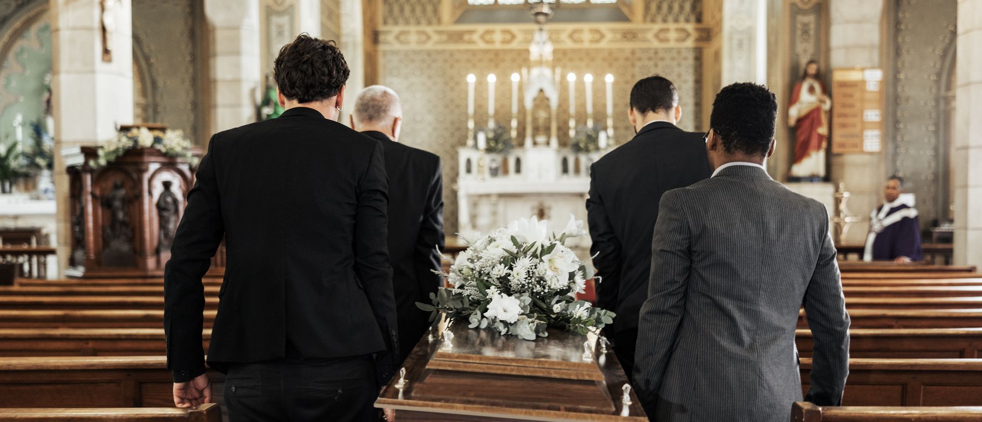 Des porteurs conduisent un cercueil dans une église.