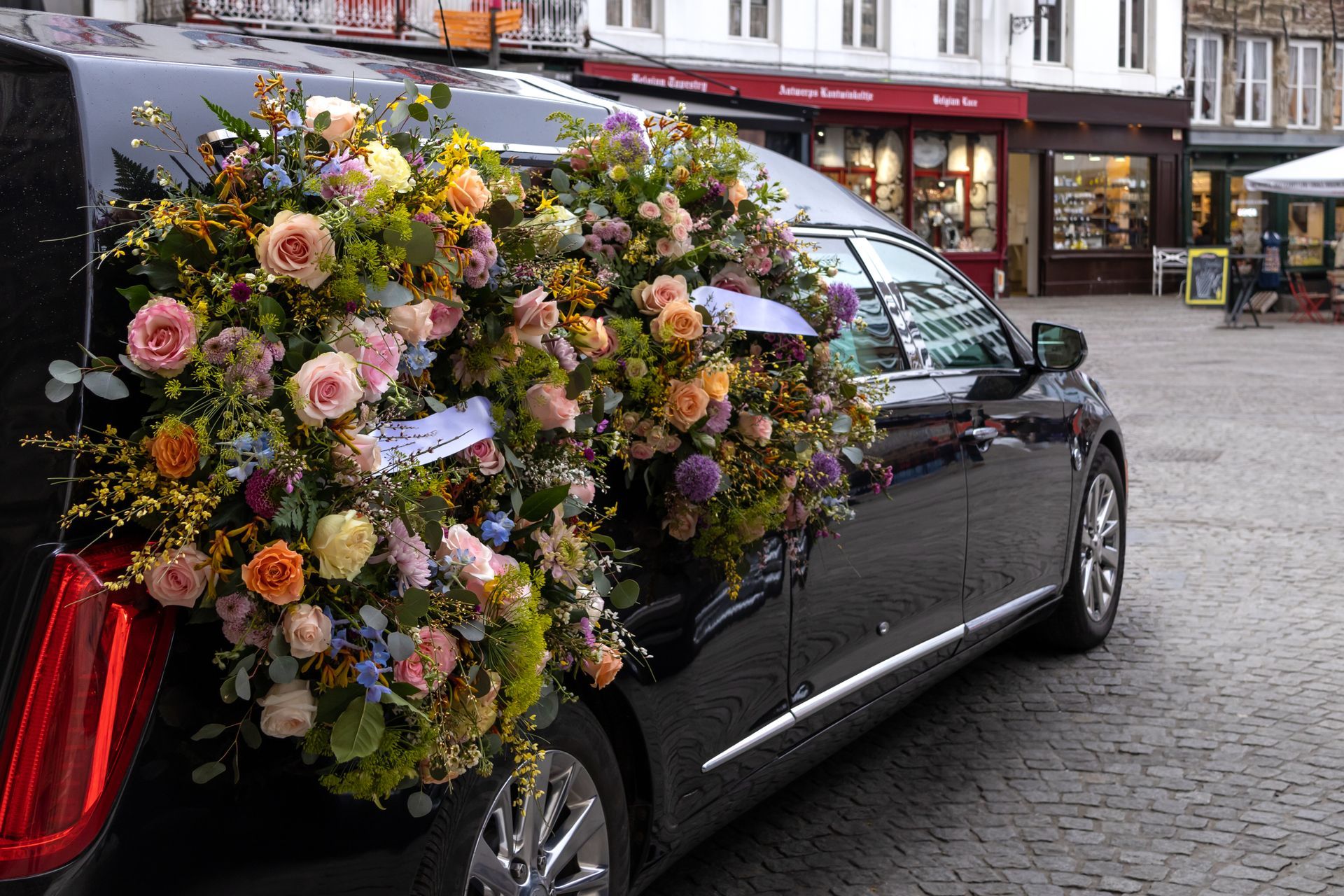 Un corbillard avec des gerbes de fleurs.