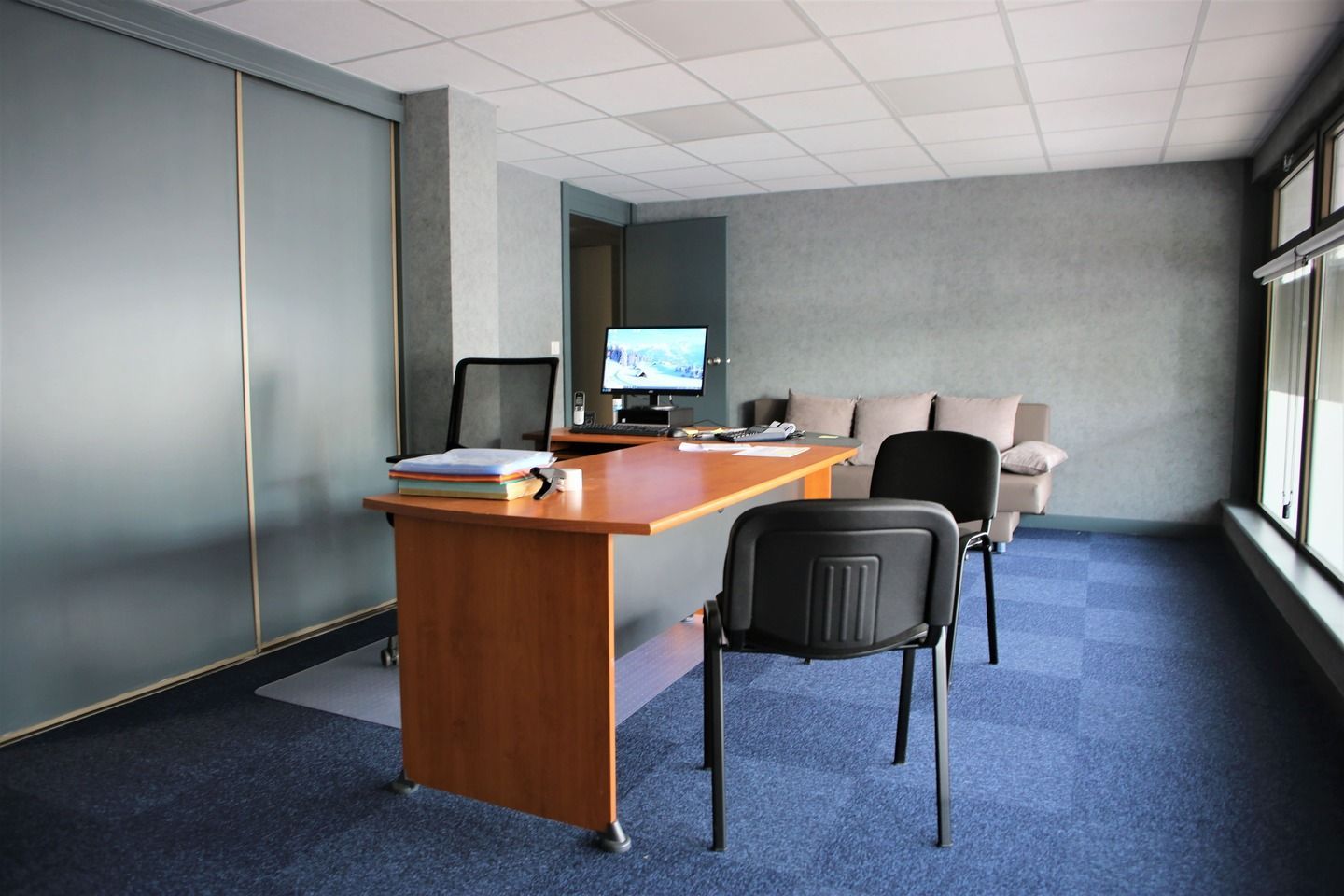 Une pièce avec un bureau et des chaises.
