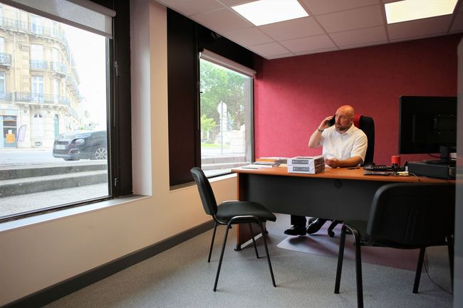 Un conseiller funéraire au téléphone, assis à son bureau.