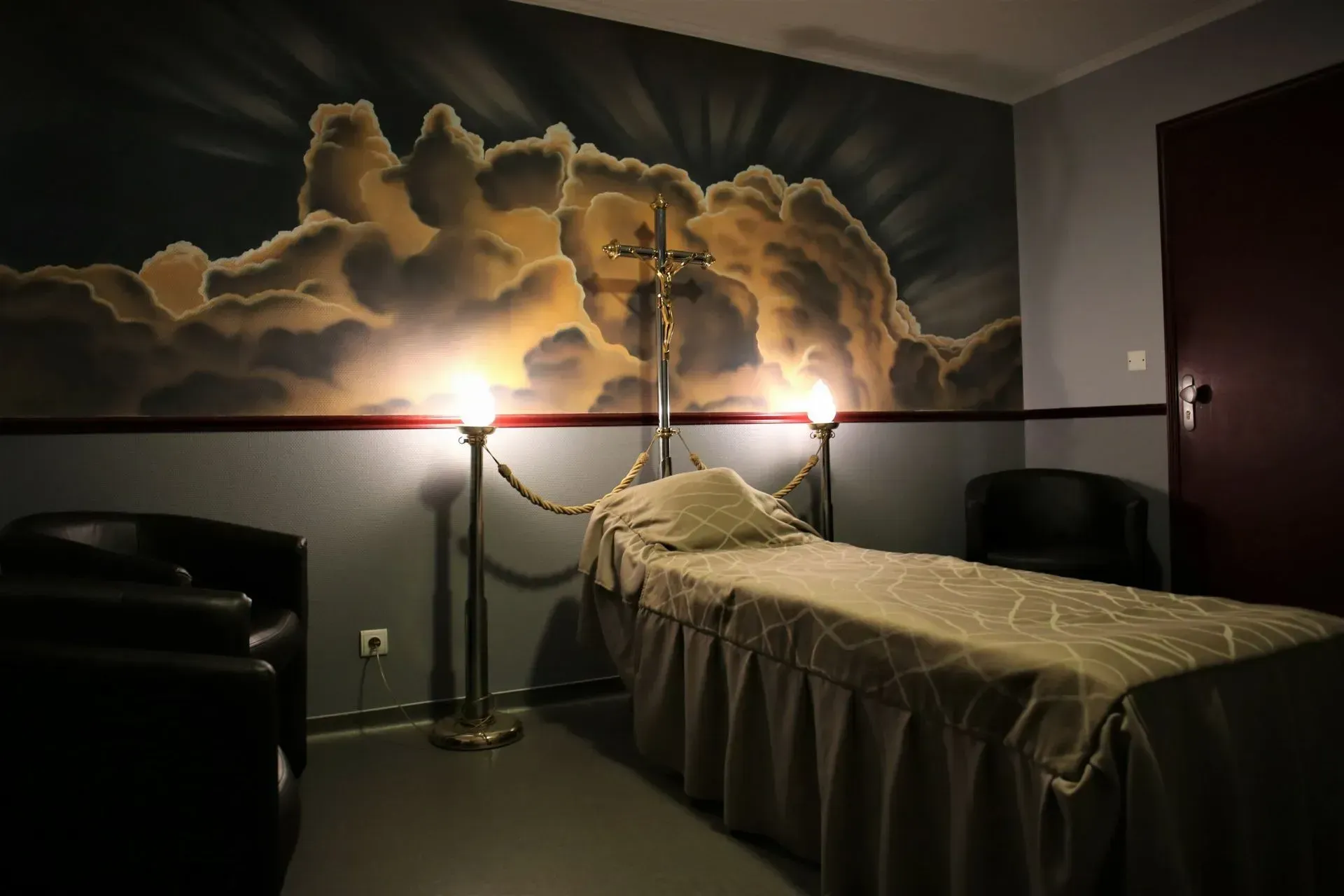 Une chambre funéraire avec un lit et une croix.