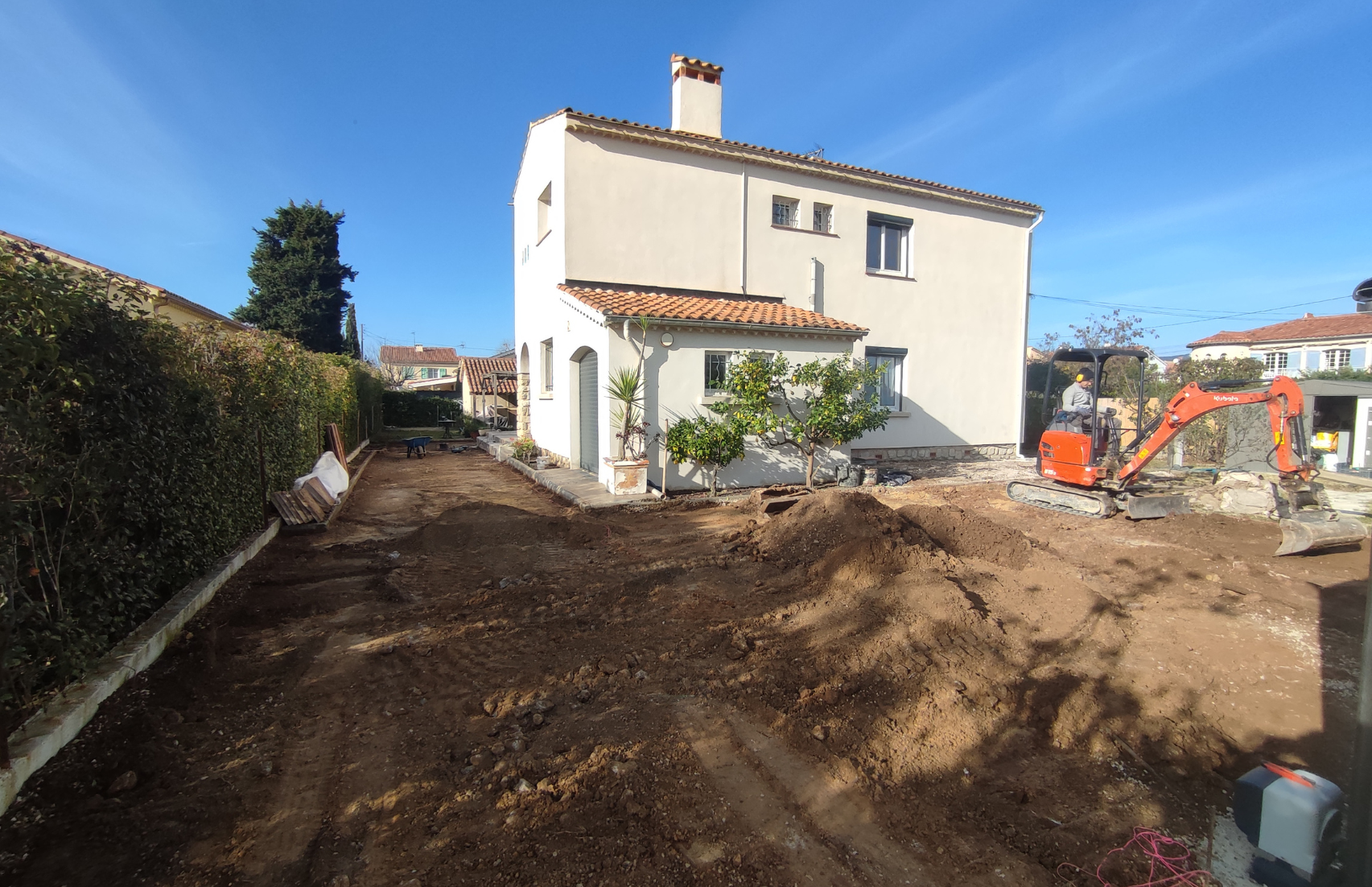 Une grande maison blanche avec beaucoup de terre devant.