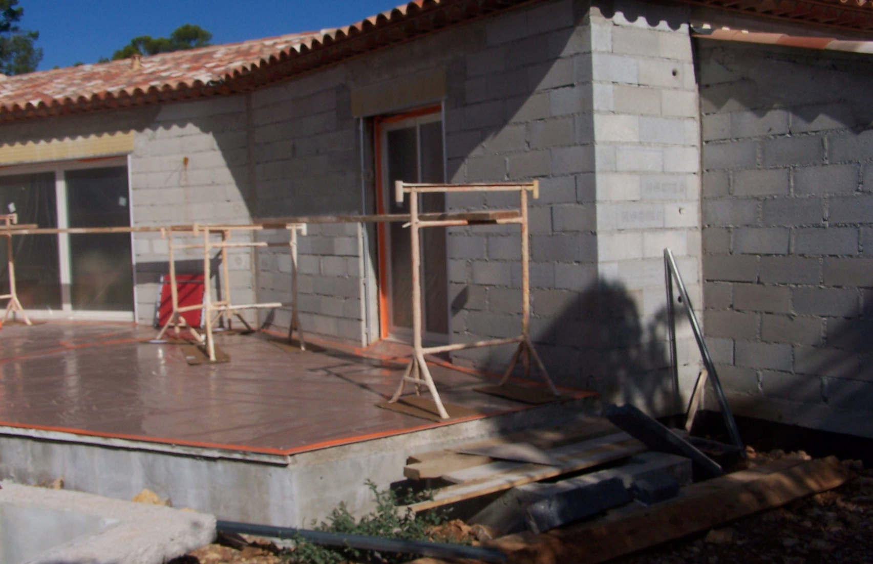 Une maison en construction avec des briques et un toit en tuiles