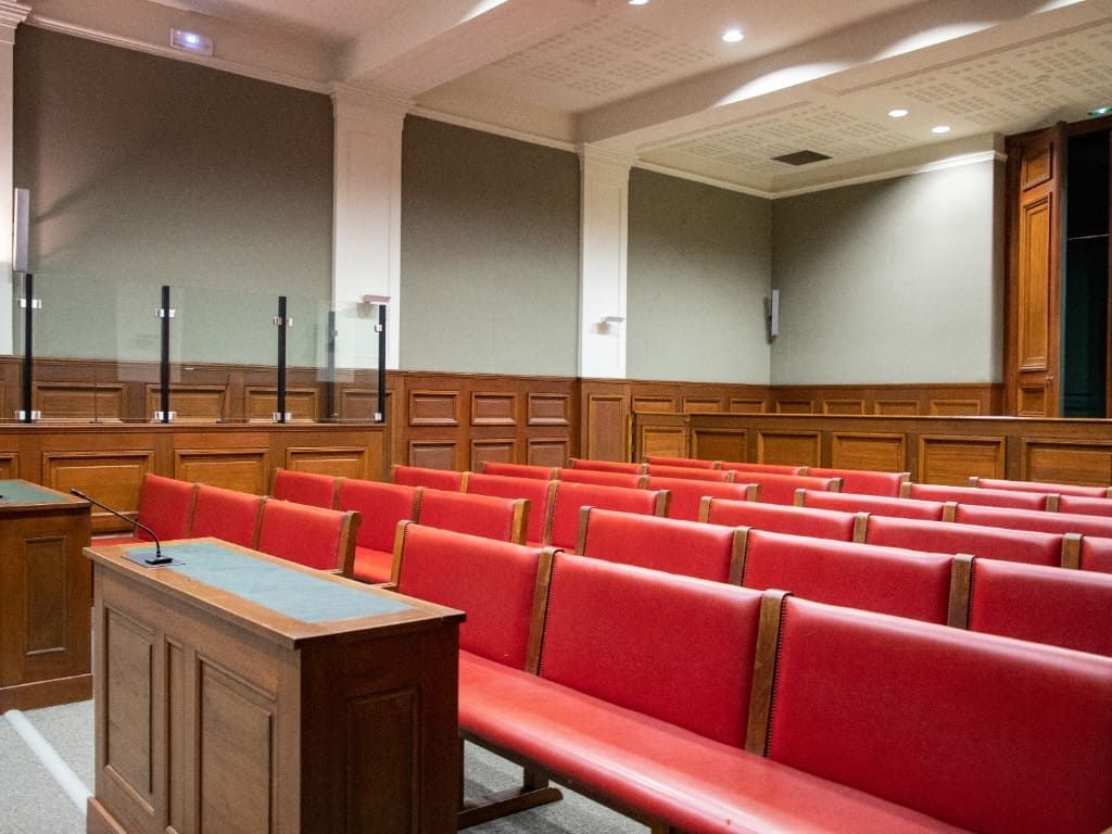 Una fila de bancos de cuero rojo en una sala del tribunal