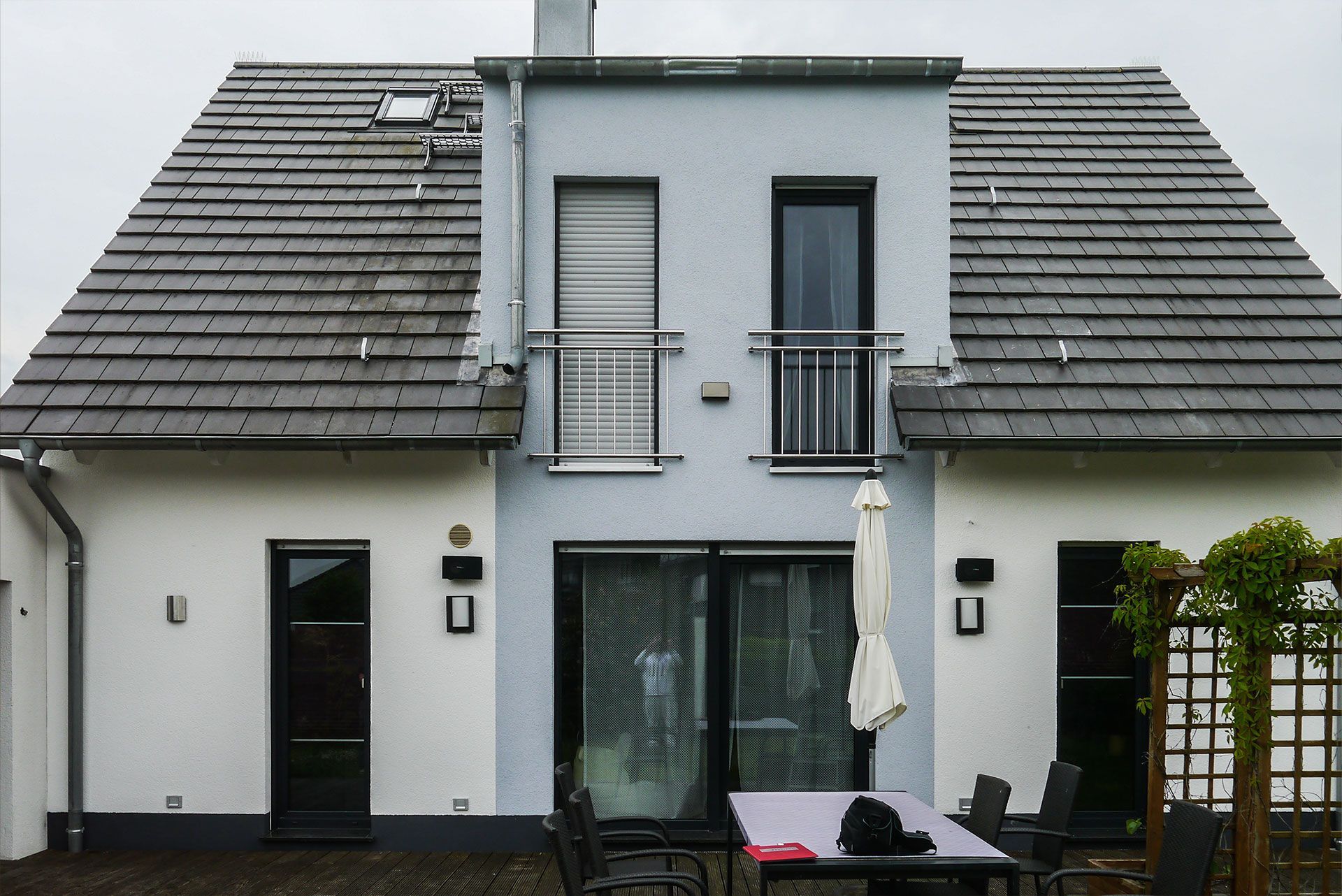 die Rückseite eines Hauses mit einem Tisch und Stühlen davor