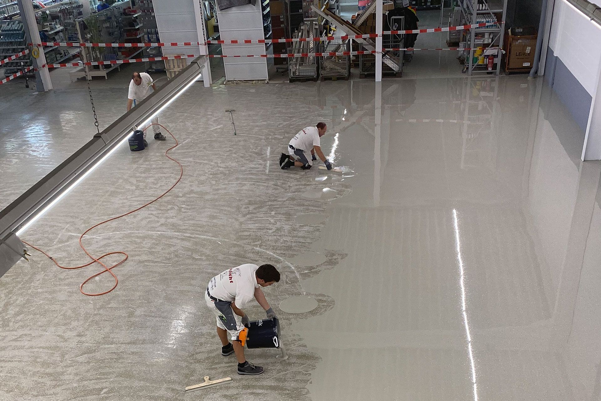 Eine Gruppe Männer arbeiten mit Epoxidharz am Boden