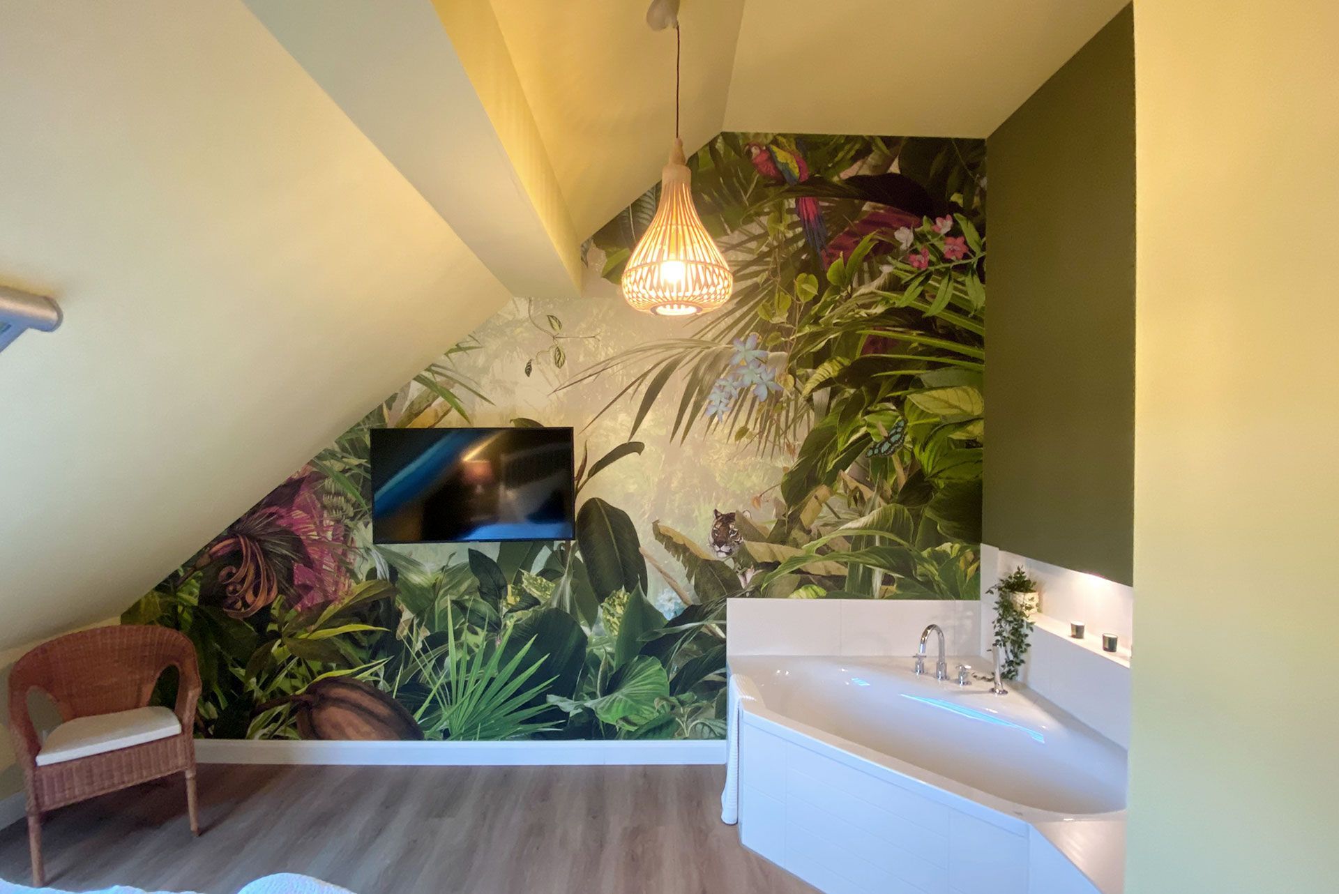 ein Badezimmer mit Badewanne und einem Fernseher an einer tapezierten Wand.