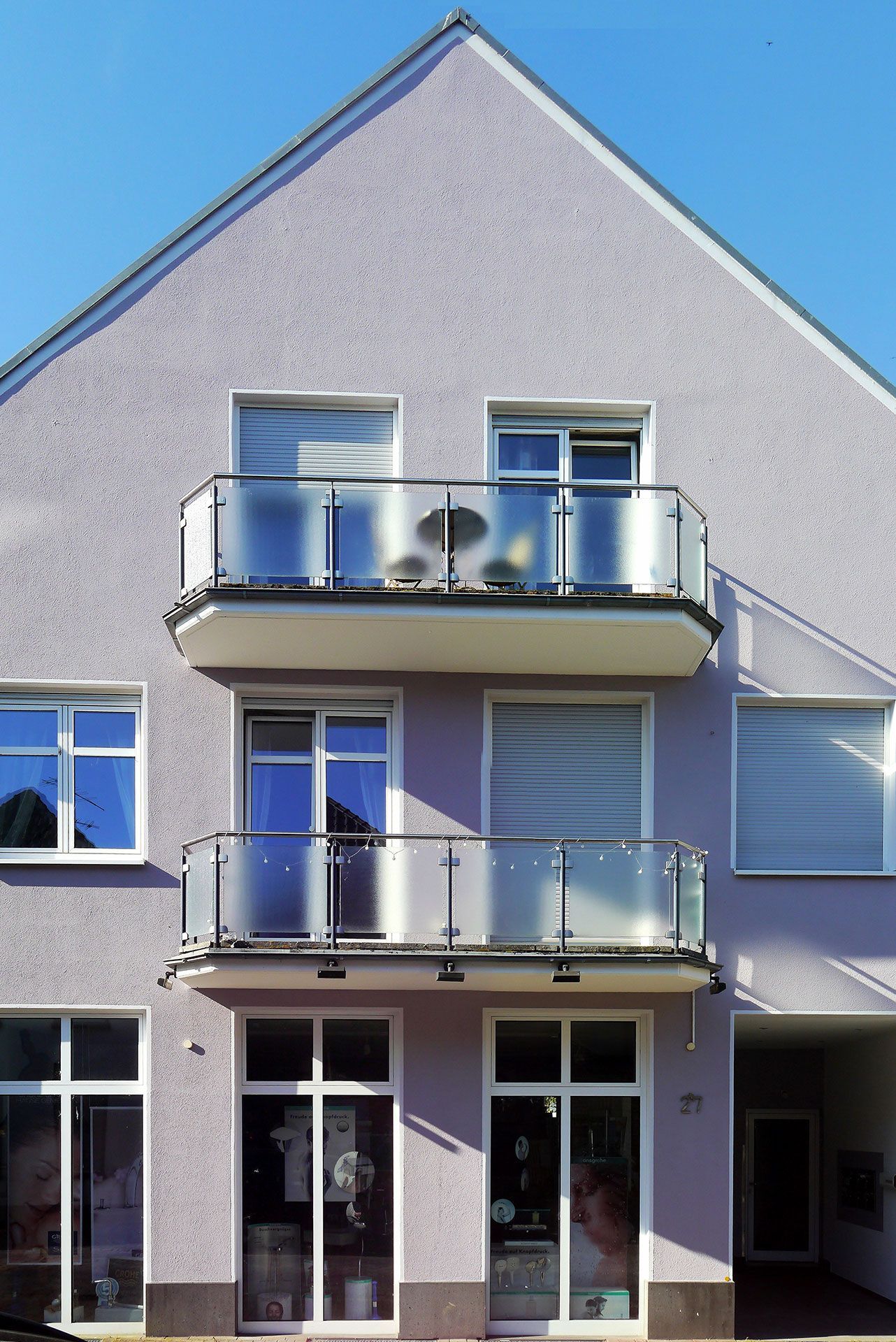 Helle Hausfassade mit zwei Balkonen