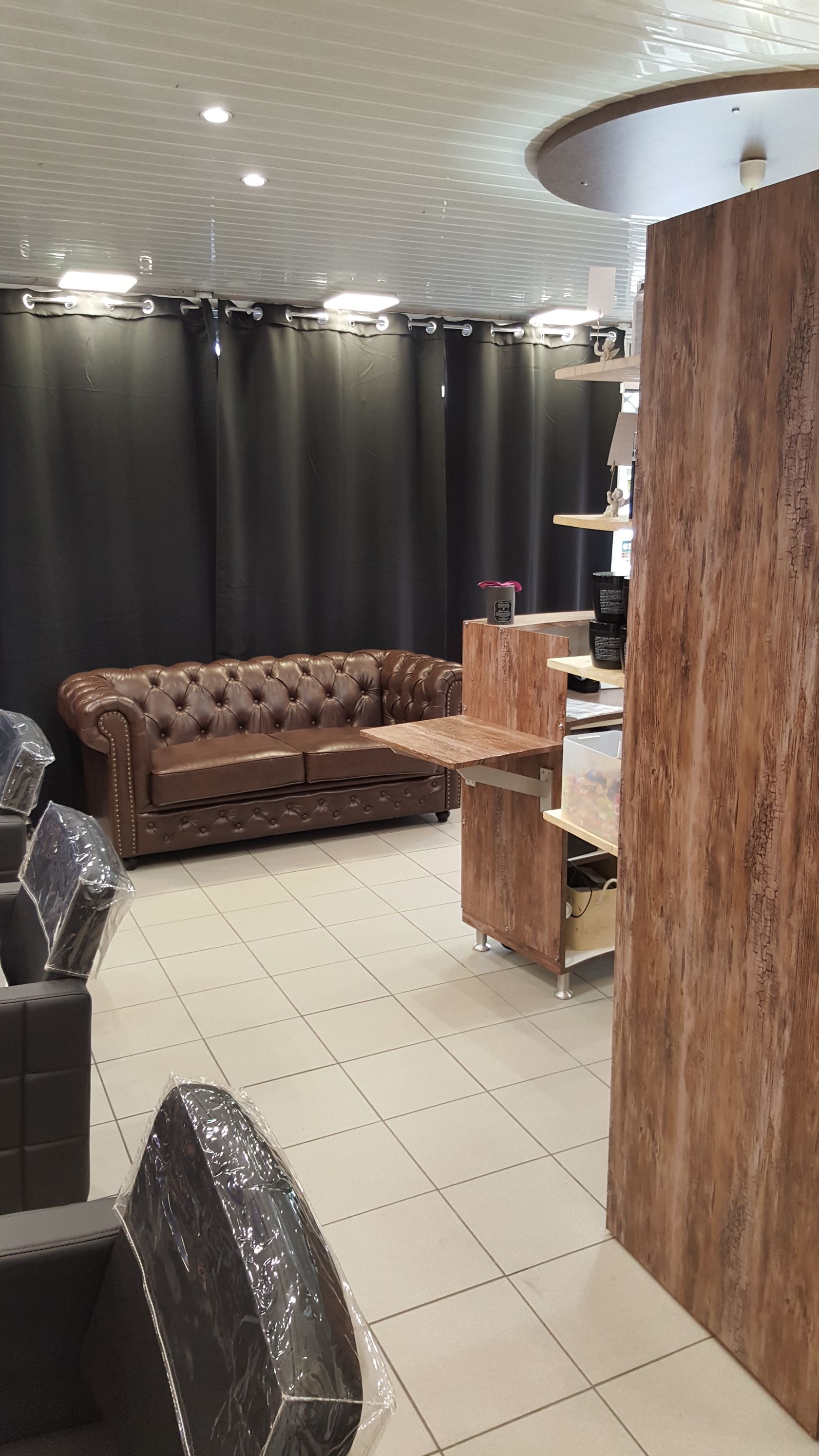 Espace attente du salon avec canapé et haut des fauteuils