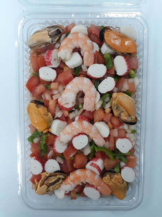Un recipiente de plástico lleno de camarones, mejillones y tomates.