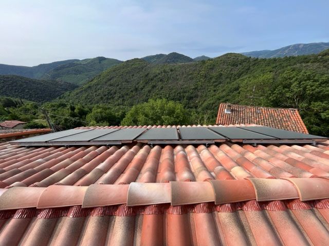 Panneaux solaires thermiques sur une toiture en tuiles romanes