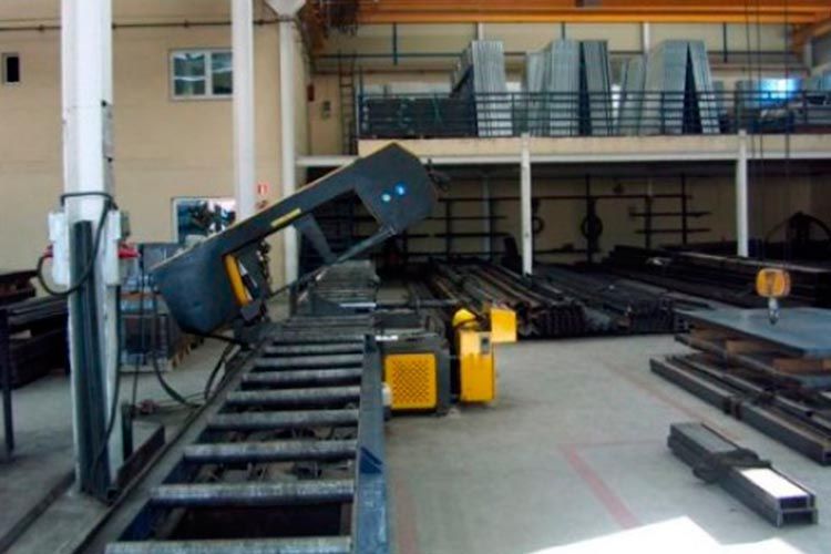 Una máquina está cortando una pieza de metal en una fábrica.