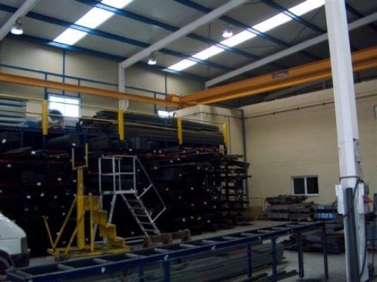 Un gran almacén con grúa y escaleras.