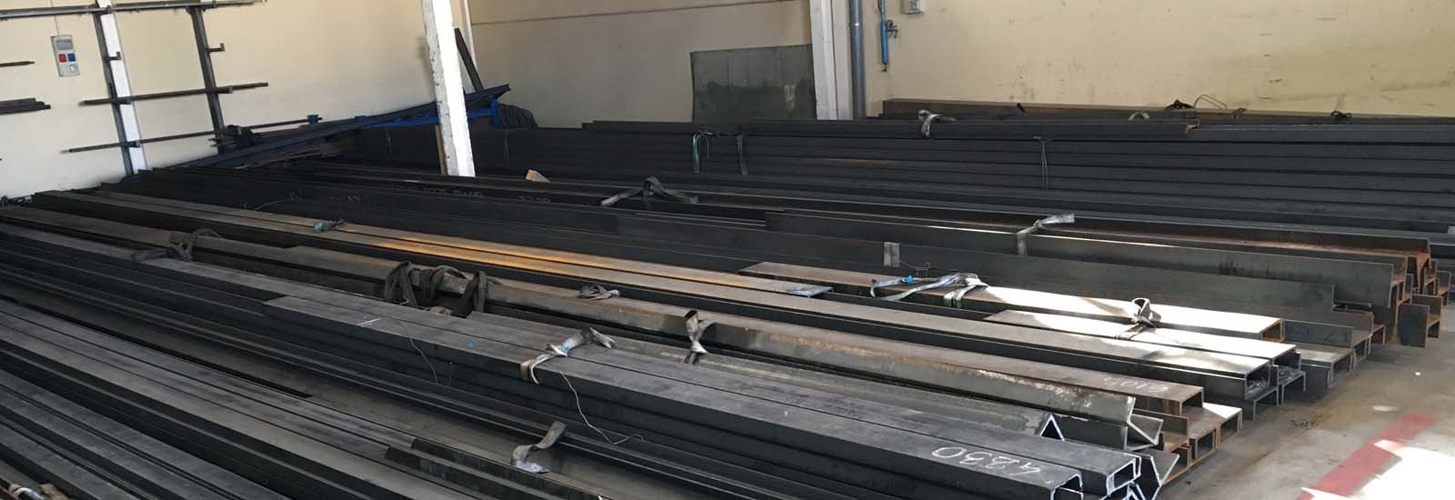 Un almacén lleno de muchas piezas de metal apiladas una encima de otra.