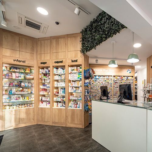 Una farmacia con muchos estantes y un mostrador.