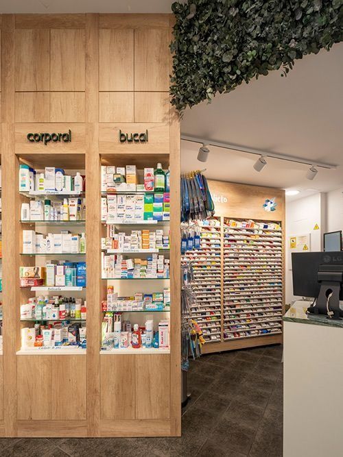 Una farmacia con estantes de madera llenos de muchos medicamentos.