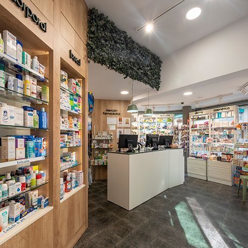 Una farmacia con muchos estantes y un mostrador.