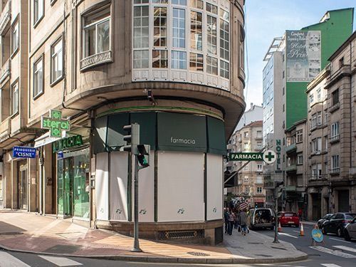 Una esquina de una calle de la ciudad con una farmacia en el medio.