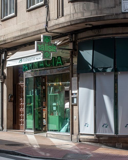 Una farmacia con una cruz verde en el frente.
