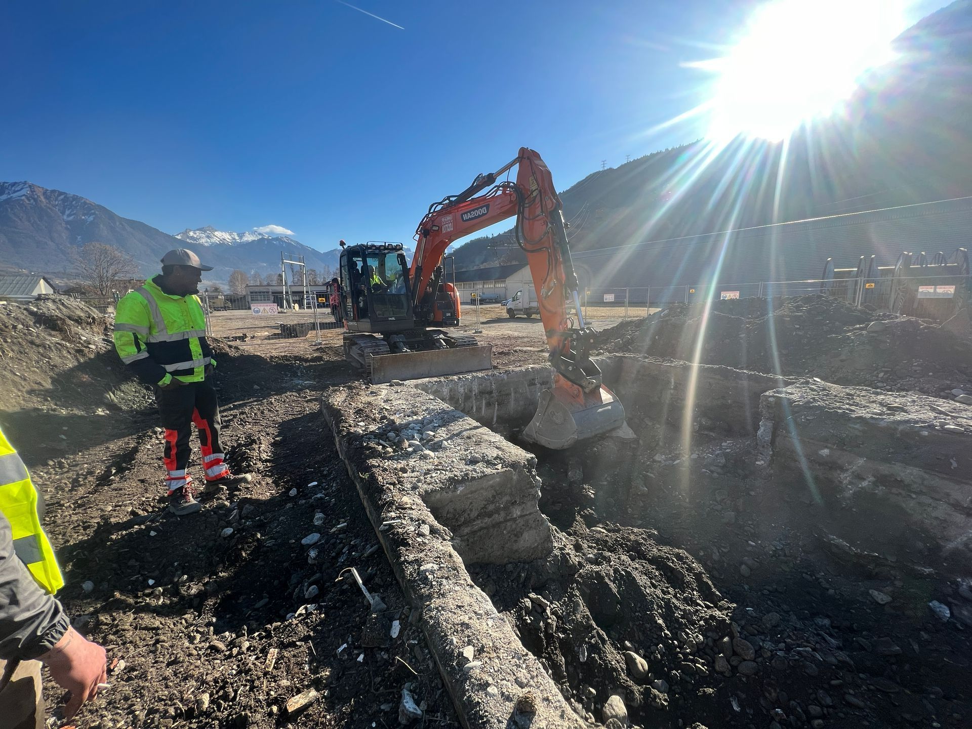 Deux hommes sur un chantier et un engin