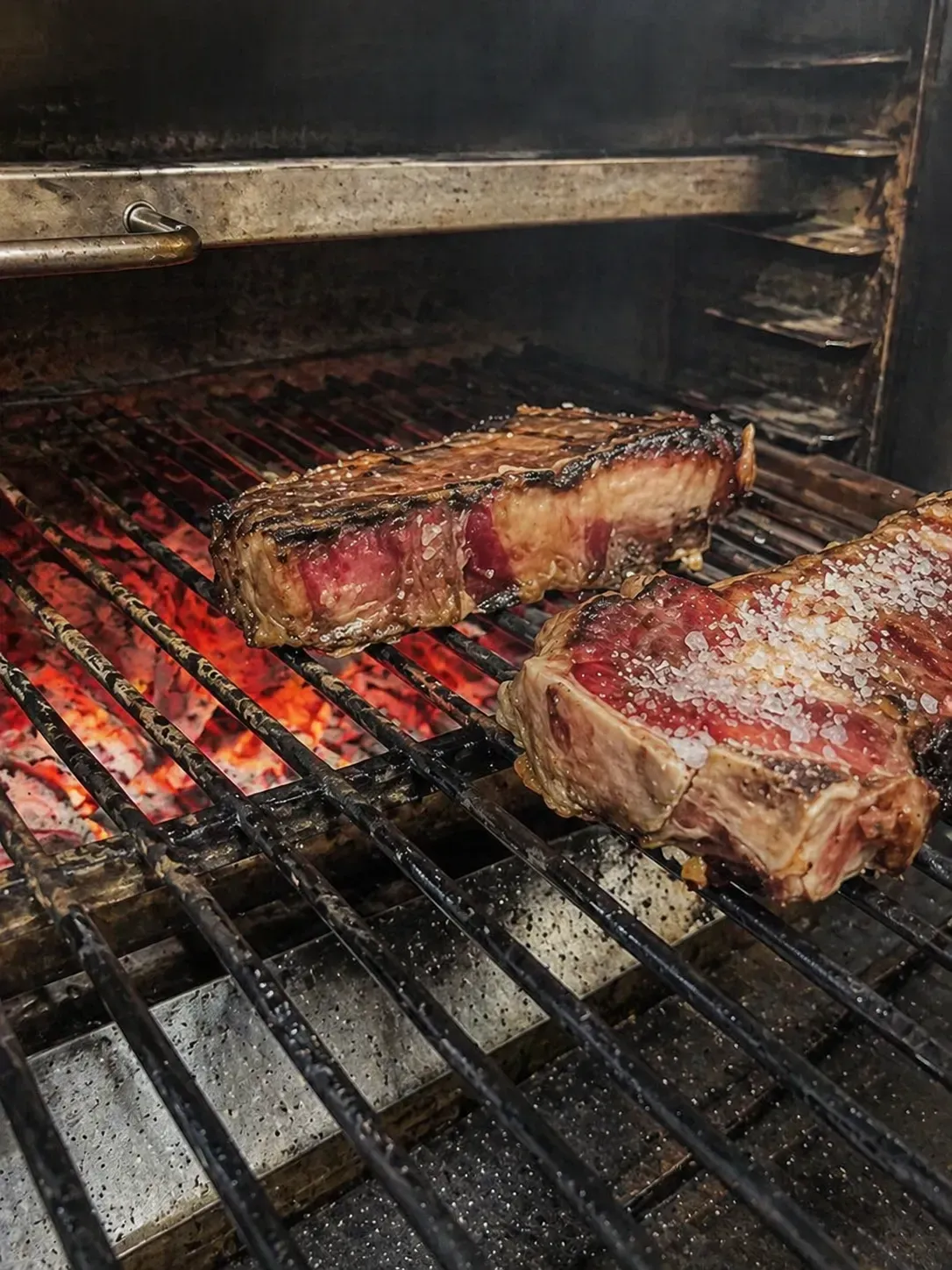 Paella de marisco en sartén negra con gambas y rodajas de limón.