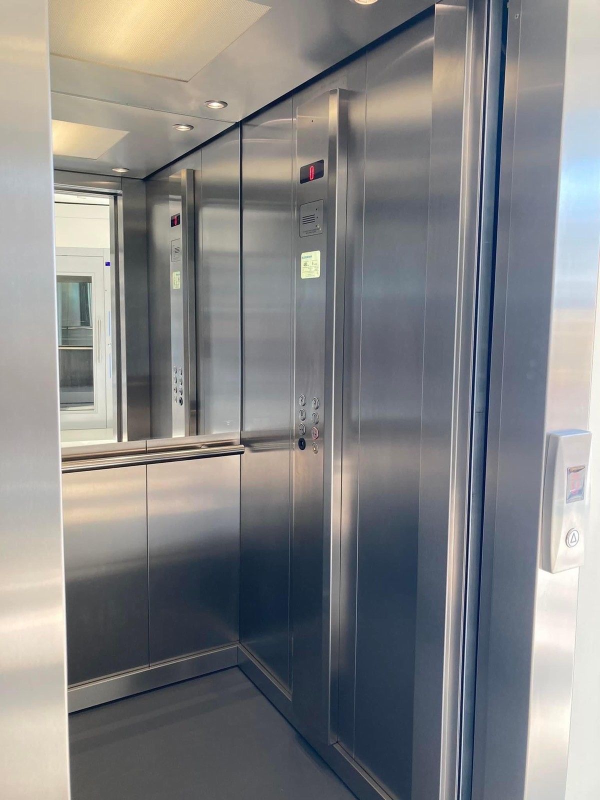 Άδειο εσωτερικό ανελκυστήρα από ανοξείδωτο χάλυβα με καθρέφτες στους τοίχους και κλειστές πόρτες