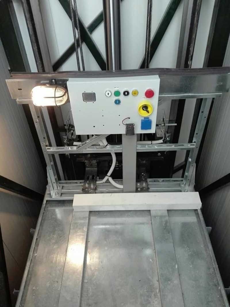 Βιομηχανική πλατφόρμα ανύψωσης με πίνακα ελέγχου, κουμπιά και μεταλλικό δίσκο φόρτωσης σε περιβάλλον αποθήκης