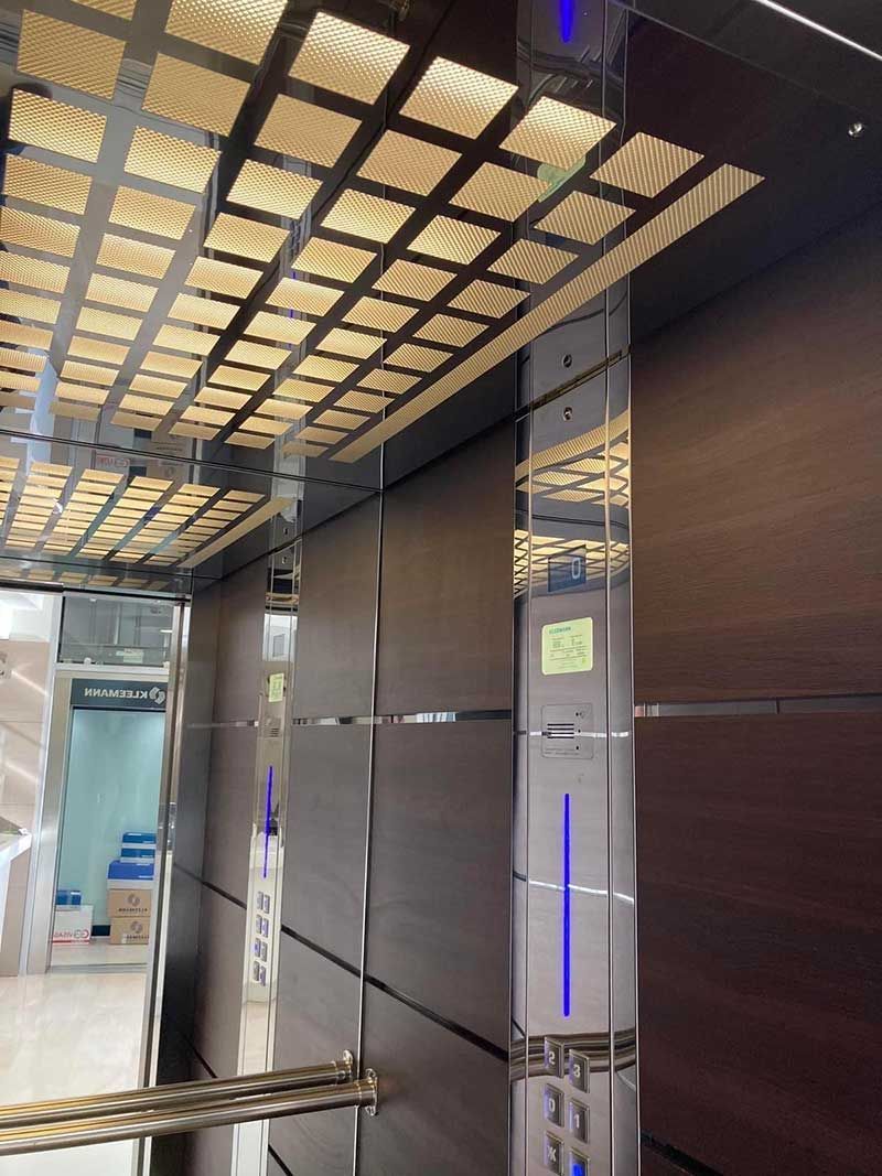 Μοντέρνος διάδρομος με καφέ τοίχους, κολώνες με καθρέφτες και οροφή με σχέδια και μπλε φώτα