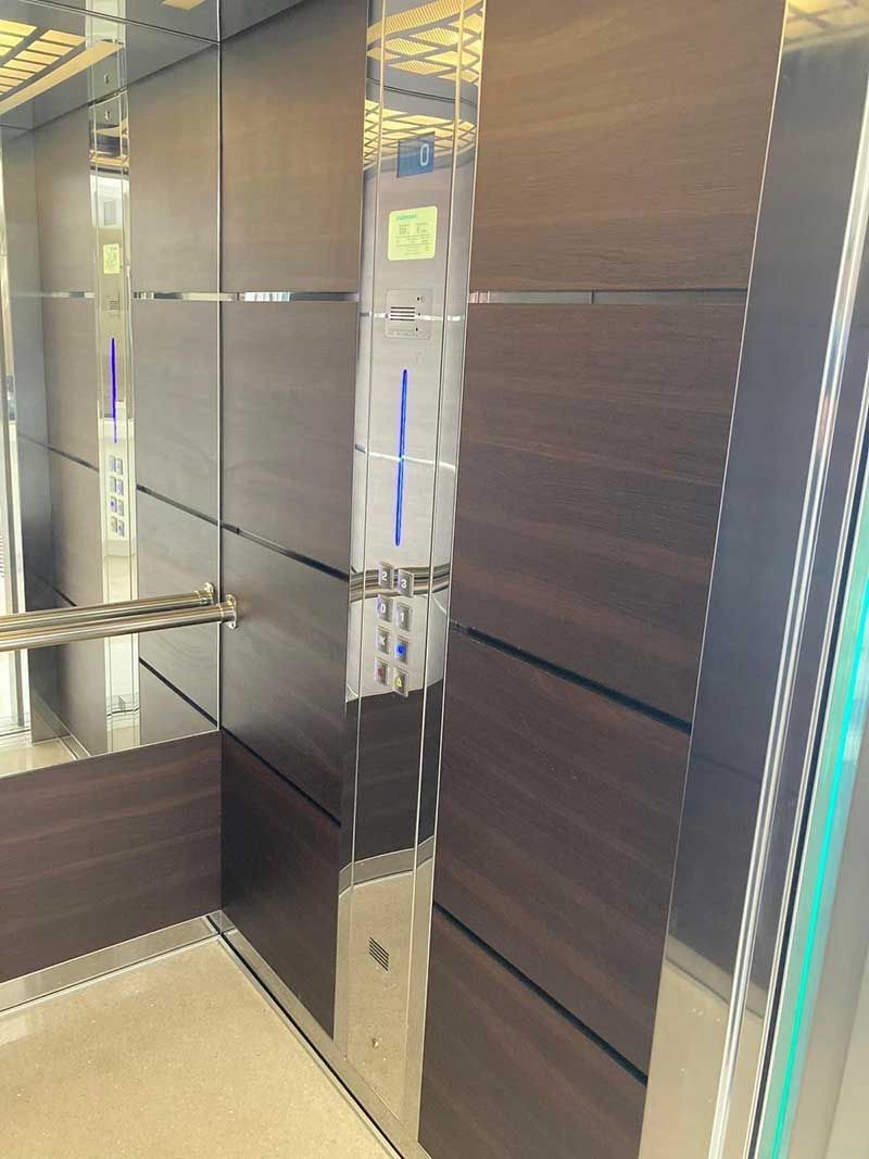 Εσωτερικό ανελκυστήρα με καθρέφτη, πάνελ από σκούρο ξύλο και μεταλλικό κιγκλίδωμα