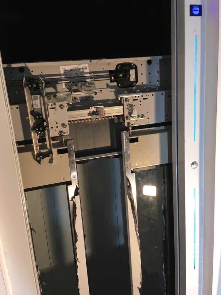 Άνω όψη ενός μεταλλικού μηχανισμού ανελκυστήρα με καλώδια και πάνελ μέσα σε ένα φρεάτιο