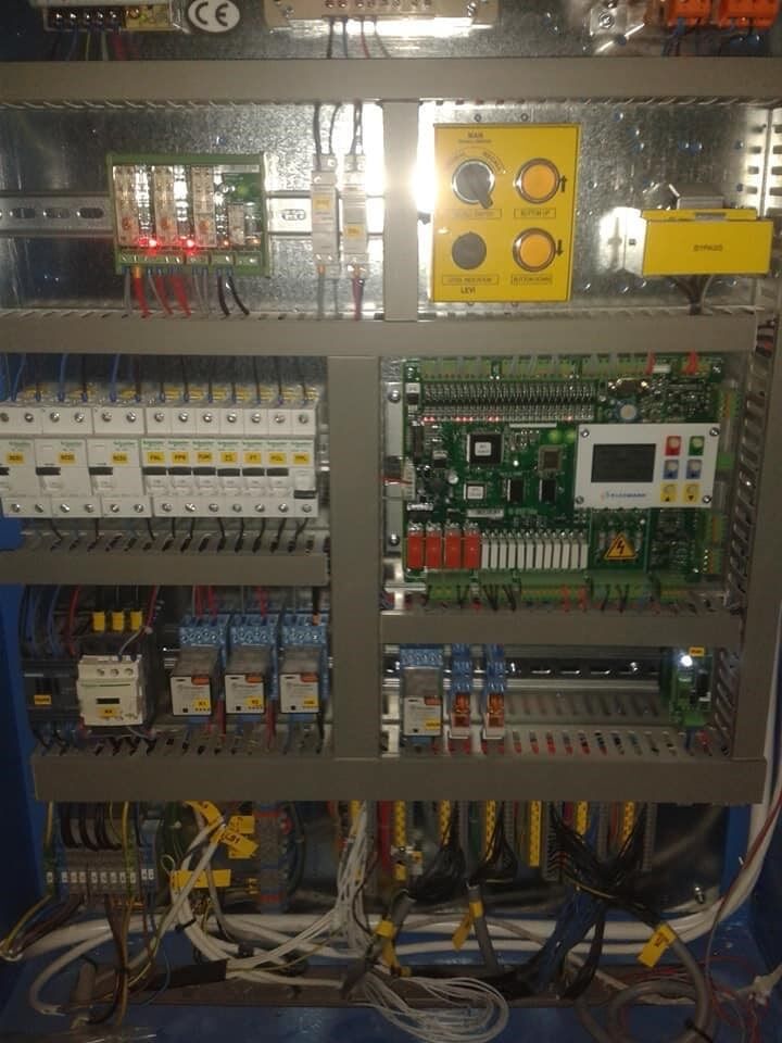 Ανοίξτε τον ηλεκτρικό πίνακα ελέγχου με τους διακόπτες κυκλώματος, την καλωδίωση, τα ρελέ και μια κίτρινη μονάδα ελέγχου.