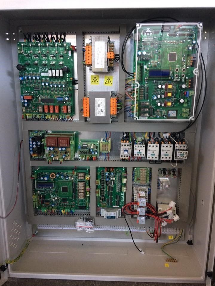 Ανοιχτός ηλεκτρικός πίνακας ελέγχου με πλακέτες κυκλωμάτων, ρελέ και καλωδίωση στο εσωτερικό.