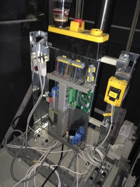 Ανοιχτός ηλεκτρικός πίνακας ελέγχου με καλώδια, πλακέτες κυκλωμάτων και τοποθετημένες συσκευές σε σκοτεινό βιομηχανικό περιβάλλον