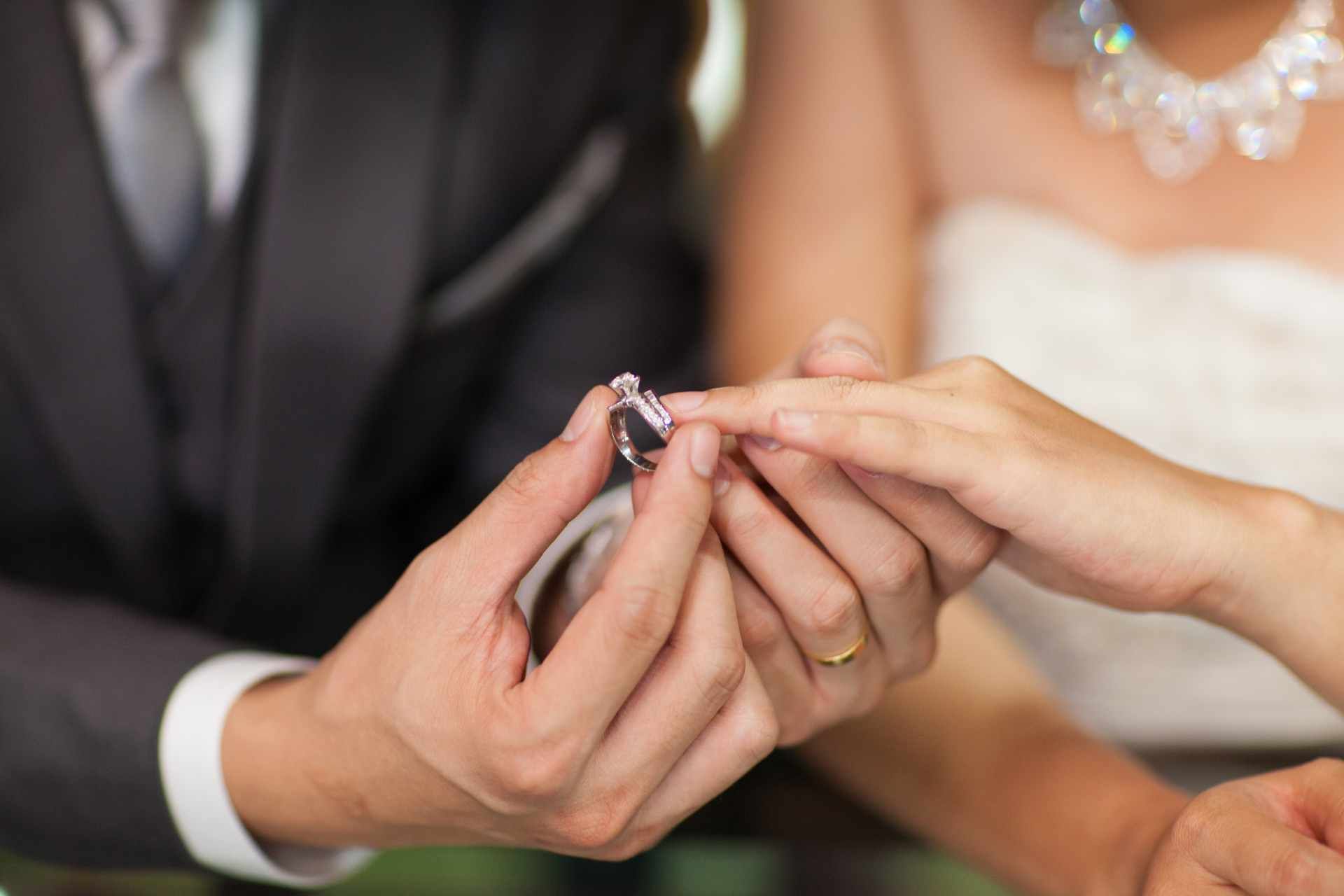 Braut und Bräutigam stecken sich gegenseitig die Hochzeitsringe an