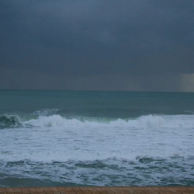 Las olas rompen en la playa en un día nublado.