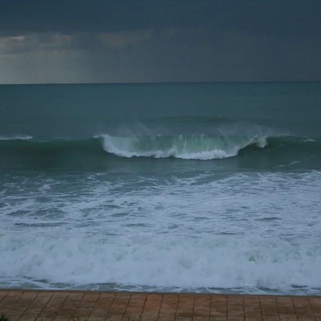 Un día tormentoso en la playa con olas rompiendo en la orilla.