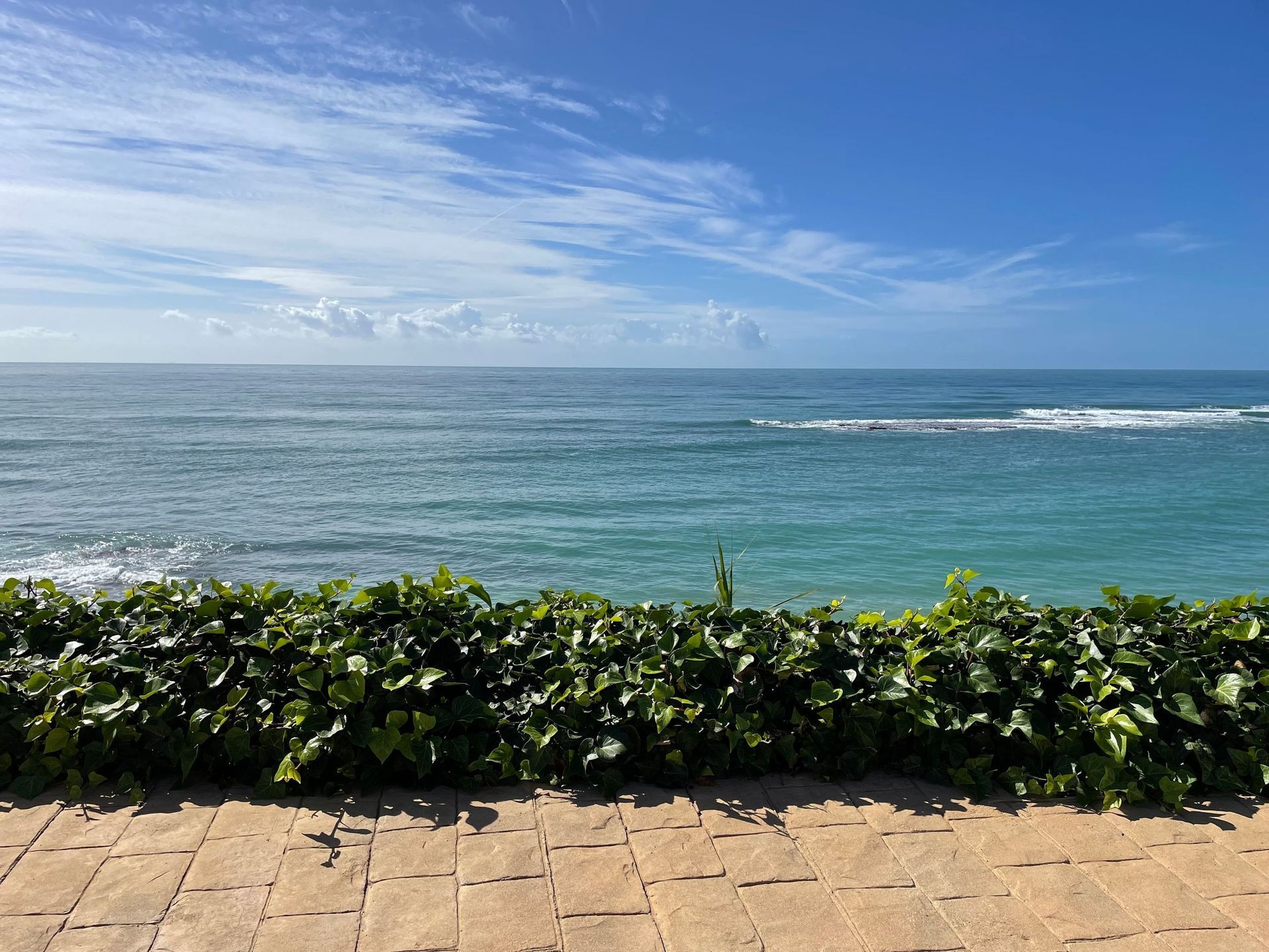 Una vista del océano desde una pasarela de ladrillos.