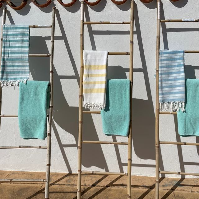 Una fila de escaleras de madera con toallas colgadas en ellas.